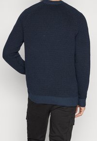 Pullover navy in maglia con motivo a nido d'ape, polsini e orlo a coste, scollatura rotonda e vestibilità rilassata.