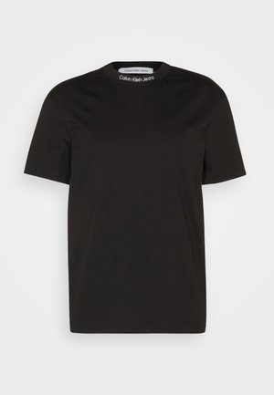Black short-sleeve t-shirt made of cotton, featuring a round neckline with the "Calvin Klein Jeans" logo on the collar. Smooth texture.