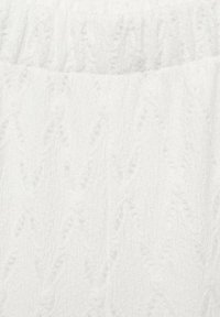 Witte badstof met een textuurpatroon met diagonale golven en lichte richels. Zacht en absorberend materiaal.