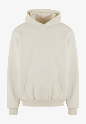 Krém színű kapucnis pulóver puha anyagból, kenguru zsebbel, bordás mandzsettákkal és alsó szegéllyel, a mellrészen diszkrét, dombornyomott logóval.