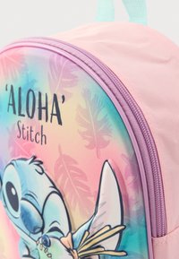 Rožinė kuprinė su gradientiniu dizainu, mėlynu Stitch personažu, tropinių lapų raštais ir violetine užtrauktuku. Papildyta šviesiai žaliomis petnešomis.