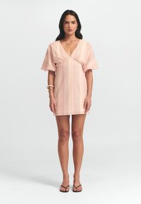 Abito a righe rosa con scollatura a V e maniche corte a volant, realizzato in tessuto leggero. Lunghezza sopra il ginocchio con vestibilità comoda.