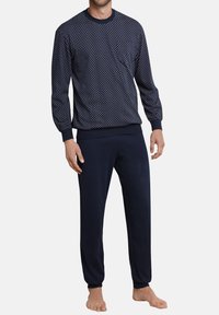 Marineblaues Langarmoberteil mit weißen Punkten, kombiniert mit einfarbigen marineblauen Jogginghosen. Hergestellt aus weichem Stoff mit gerippten Bündchen.