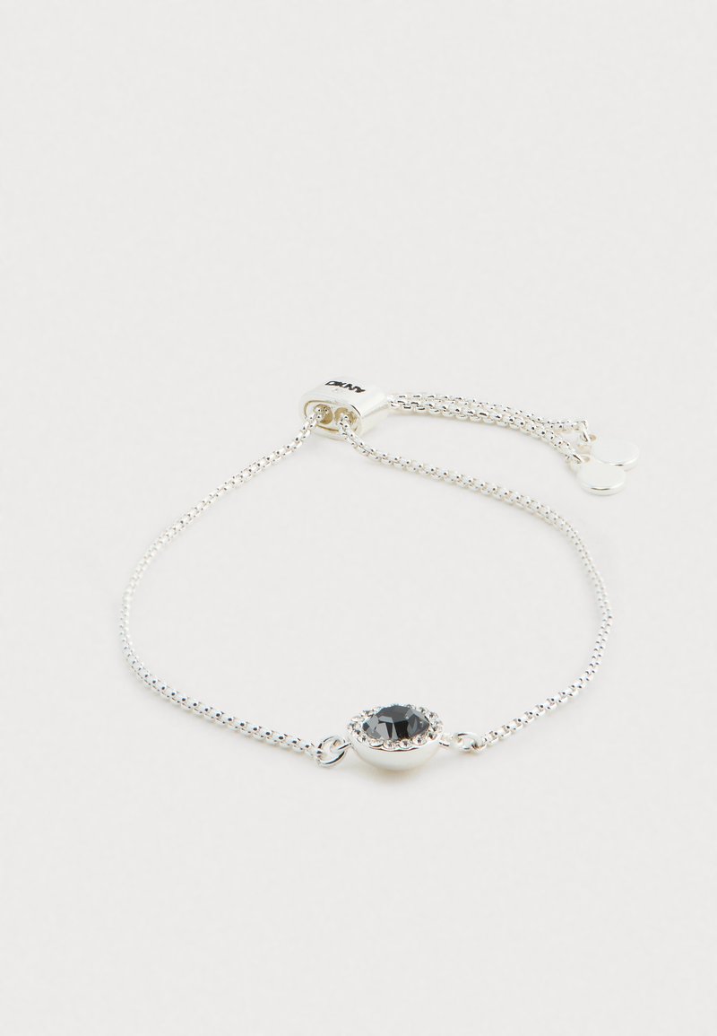Silberne Kettenarmband mit einem ovalen schwarzen Stein als Mittelstück, umgeben von klaren Strasssteinen; verstellbarer Verschluss mit kleinen runden Akzenten.