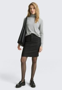 Pull en col roulé gris, jupe crayon en denim noir, collants opaques noirs, mocassins noirs, avec un grand sac noir. Design simple et ajusté.