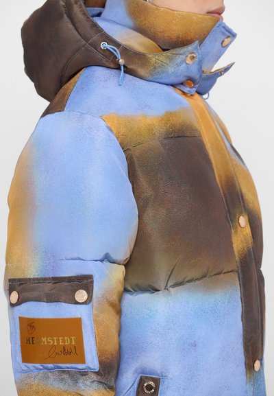 Gepolsterte Jacke in Blau und Braun mit glänzender, strukturierter Oberfläche. Verfügt über einen hohen Kragen, Druckknöpfe und eine Brusttasche mit einem Logo-Patch.