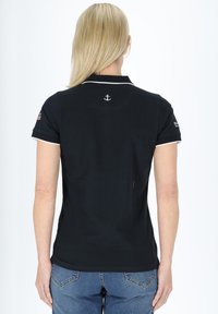 Sort polo skjorte med hvid kravesnor, prydet med en lille ankerbrodering på ryggen. Materialet ser glat og strækbart ud.