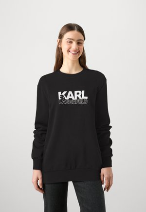 Black sweatshirt with long sleeves, crew neck, featuring a prominent white logo of "KARL LAGERFELD" on the front. Smooth texture.
