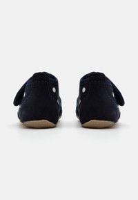 Tamsiai mėlyni nubuko batai su minkšta tekstūra, papuošti baltais taškeliais ir lankščiu guminio pado, su mažomis užpakalinėmis kilpomis.