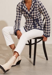 Navy och kräm randig kavaj med knytbälte, ihopparat med vita cropped byxor och krämfärgade klackade ankelstövlar.