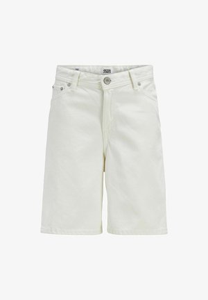 Világos bézs színű, hosszú ujjú pulóver hímzett logóval, világos bézs rövidnadrággal és fehér sportcipővel párosítva. Egyszerű, laza megjelenés.