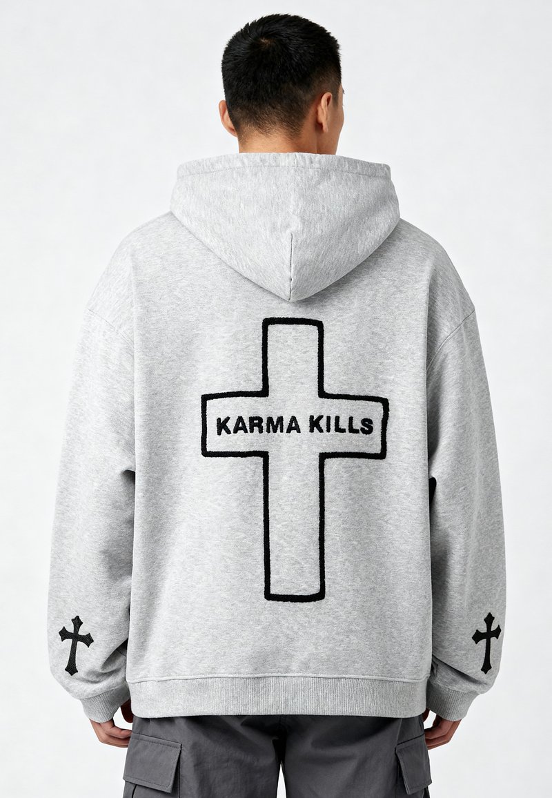 Felpa grigia con cappuccio, caratterizzata da una grande croce nera e dal testo "KARMA KILLS" sul retro, con croci più piccole sulle maniche.