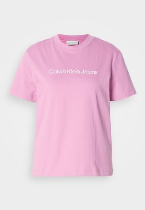 T-shirt in cotone rosa con maniche corte e scollatura a girocollo, con la scritta "Calvin Klein Jeans" stampata in bianco sul petto.