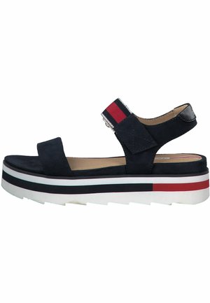 Marineblå ruskindssandaler med en bred rem, justerbar spænde og lagdelt platformssål med røde, hvide og sorte striber.