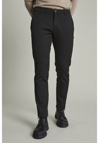 Svarta byxor med slim fit, med knappstängning och sidofickor. Tillverkade av ett mjukt, stretchigt tyg för komfort.