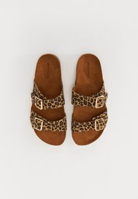 Sandály s leopardím vzorem, se dvěma nastavitelnými popruhy, doplněné zlatými sponami a hnědým texturovaným stélkou. Ploché podpatek, otevřená špička.
