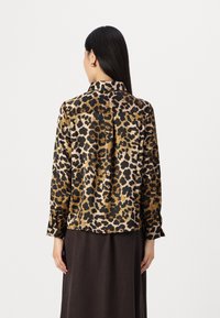Leopardenmuster-Bluse aus braunem, schwarzem und beigem Satin; verfügt über einen Kragen, Knopfmanschetten und hat eine lockere Passform mit einer Mittelnaht im Rücken.