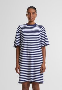 Gestreepte T-shirt jurk met brede marineblauwe en witte horizontale strepen, korte mouwen en een ronde hals, gemaakt van zachte katoenen stof.