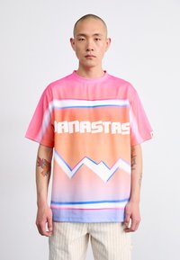 Short-sleeve t-shirt in vibrant pink and orange gradient with white text and a zigzag pattern. Smooth texture, relaxed fit, round neckline.