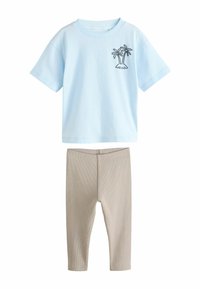 Light blue cotton t-shirt with short sleeves and palm tree graphic, paired with beige ribbed leggings. Simple design, casual fit.