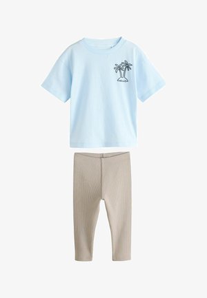 Himmelblaues Baumwoll-T-Shirt mit kurzen Ärmeln und Grafik eines Palmenbaums, kombiniert mit beigen gerippten Leggings. Einfaches Design, lässige Passform.