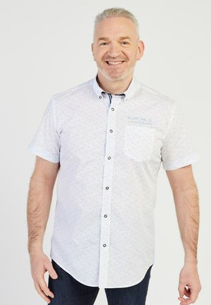 Chemise à manches courtes, boutonnée, de couleur bleu clair avec un motif à pois, comportant une poche et des boutons noirs, fabriquée en tissu lisse.
