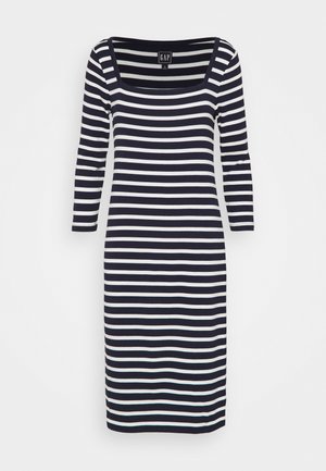 Laivastonsininen ja valkoinen vaakaraidallinen polvipituinen mekko, jossa on kolmivartiset hihat ja neliömäinen pääntie.