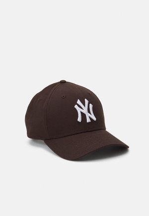 Brun baseballkasket med hvid sammenflettet NY-logo foran, seks-panel design og buet skygge på ensfarvet baggrund.