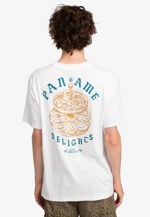 White cotton t-shirt featuring a colorful graphic design on the back, displaying stacked desserts with "PANAME DELIGHTS" text in blue and gold.