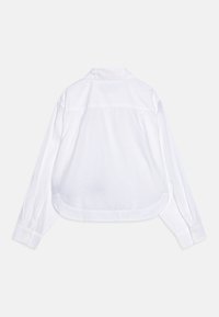 Witte langwerpige blouse met lange mouwen, gemaakt van lichtgewicht stof. Kenmerkt zich door een gebogen zoom en knoopmanchetten, zonder zichtbare patronen of accenten.