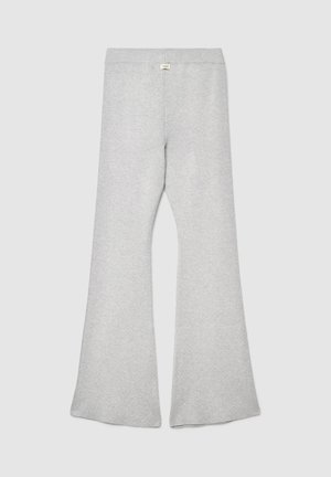 Pantalon de survêtement gris évasé en tissu doux, avec une large ceinture et une texture lisse, doté de bas évasés sans ornements visibles.