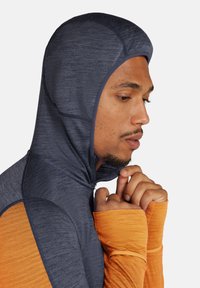 Sportieve hoodie-jack met een nav blauw bovenstuk en oranje ondermouwen, gemaakt van gestructureerde, vochtafvoerende stof.
