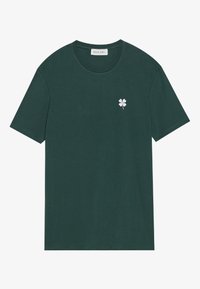 Donkergroen katoenen T-shirt met korte mouwen, ronde hals en een klein wit geborduurd klavertje op de linkerborst.