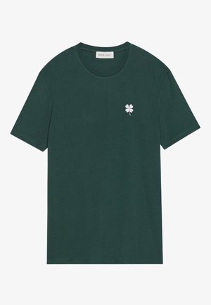 Dunkelgrünes Baumwoll-T-Shirt mit kurzen Ärmeln, Rundhalsausschnitt und einem kleinen weißen gestickten Kleeblatt auf der linken Brust.