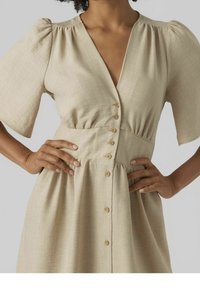Vestido beige hasta la rodilla con un escote en V profundo y mangas abullonadas. Presenta un botón al frente y una cintura fruncida, hecho de una tela texturizada.