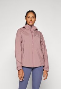 Vattentålig rosa jacka med huva, framzipper och fickor med dragkedja. Har elastiska ärmslut och en ventilerad design.
