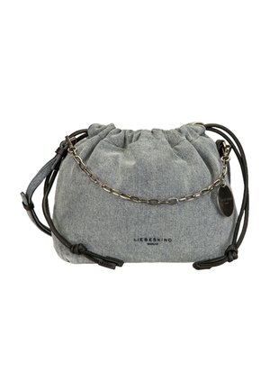 Sac en tissu gris avec cordons noirs, une poignée courte en chaîne argentée et une étiquette métallique ronde sur le côté.
