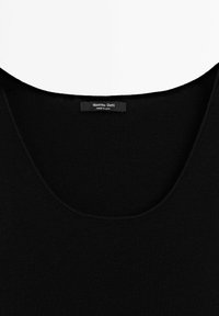 Haut noir à col rond en forme de scoop avec une étiquette de la marque Massimo Dutti visible cousue à l'intérieur du col, fabriqué en Chine.