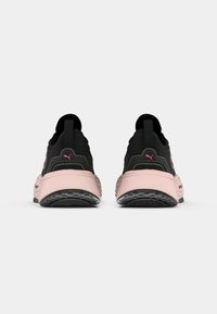 Czarne i różowe sportowe sneakersy z syntetycznej górnej części, zakrzywioną różową podeszwą środkową, teksturowaną czarną podeszwą zewnętrzną oraz wyraźnymi akcentami z logo.