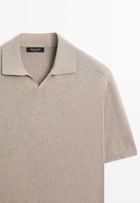 Beige strikpolo med korte ærmer, blød krave og subtil V-udskæring fra Massimo Dutti, vist på en hvid baggrund.
