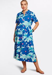 Blommig midiklänning i blått och aqua med korta ärmar, knappstängning framtill, uppvikta midja och fickor. Slätt tyg med ett livfullt mönster.