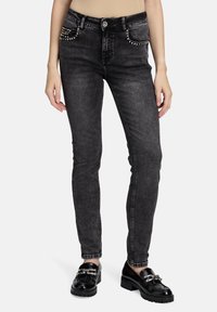 Černé skinny džíny vyrobené z denimu, s hrotovými akcenty na předních kapsách a hladkým pasem, s úzkým střihem a rovnými nohavicemi.