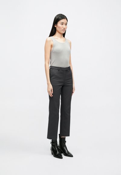 Hall gray ribbed tank top, musta kitsas slim-fit pükse ja musti madalaid saapaid terava toe ja ploki kandaga. Lihtne ja kaasaegne.