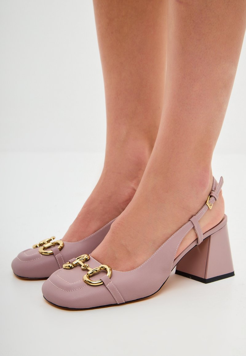 Vaaleanpunaiset slingback-korkokengät, jotka on valmistettu sileästä nahasta, ja joissa on kultaiset varusteet, neliön muotoinen kärki sekä laatikkokorko.