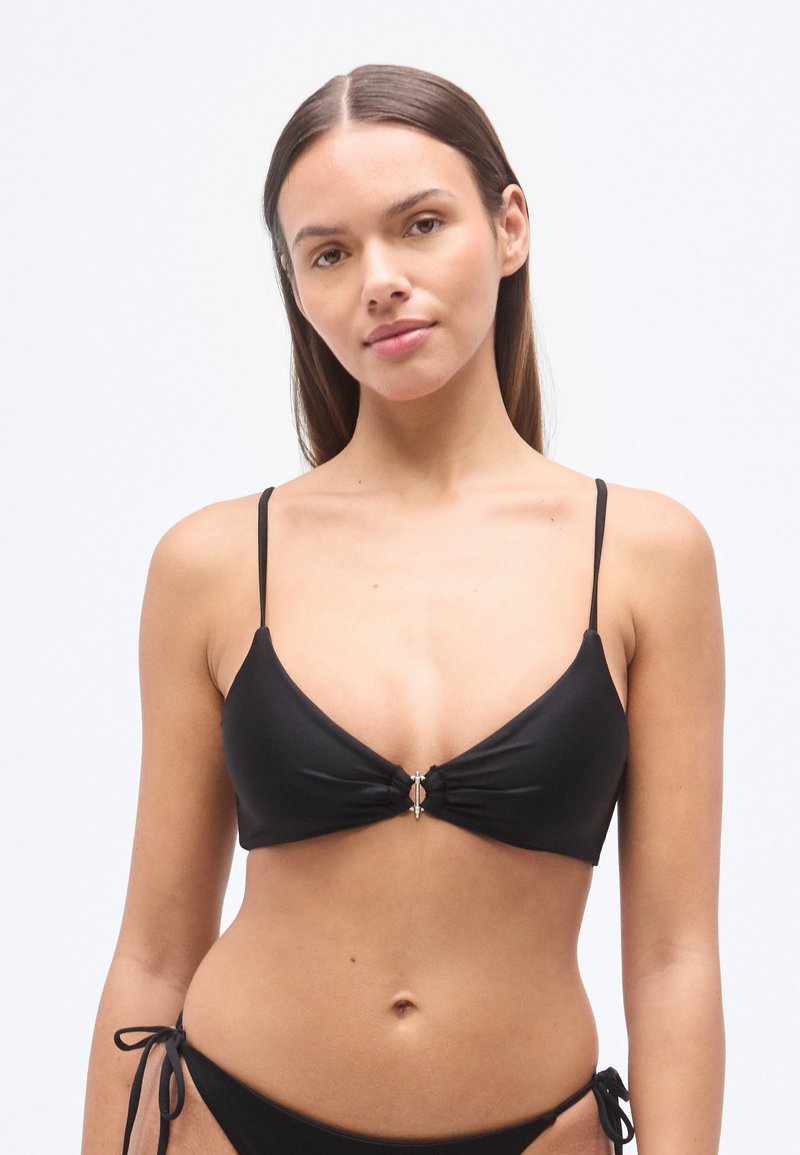 Haut de bikini noir avec bretelles fines réglables, design à coupe triangulaire, détail noué au centre et accent en métal argenté.