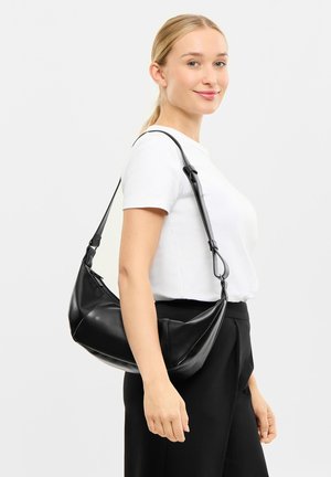 Schwarzelederhandtasche mit geschwungenem Design, verstellbarem Riemen und glatter Textur. Reißverschlussverschluss oben und minimale Hardwaredetails.