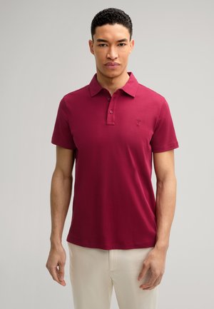 Burgunderfarbenes Poloshirt mit klassischem Kragen, Zwei-Knopf-Leiste, kurzen Ärmeln und einem gestickten Logo auf der Brust. Glattes Baumwollmaterial.