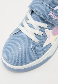 Sneaker azzurro chiaro con un tessuto texturizzato simile al denim, lacci bianchi e un accento a forma di stella rosa. Presenta una fascia in velcro e dettagli a motivo.