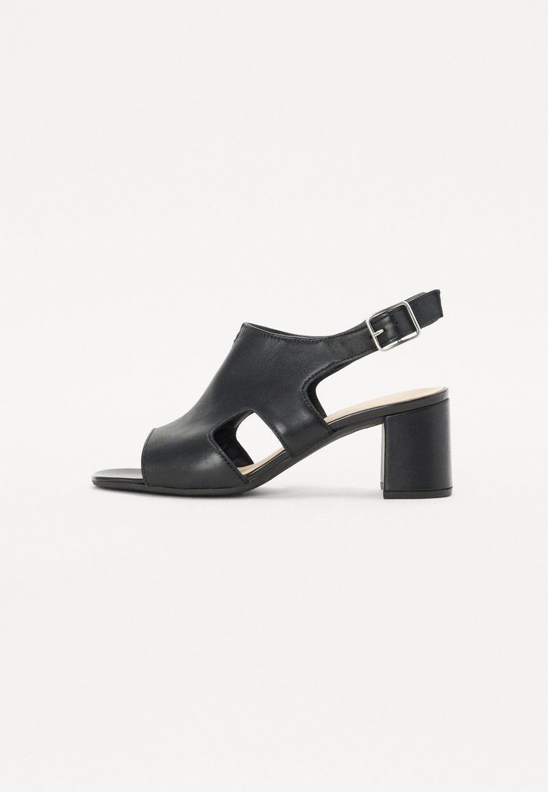 Black leather heeled sandals with open toe, side cutouts, and adjustable ankle strap. Block heel provides stable support.