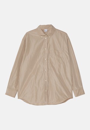 Chemise beige à manches longues avec col, poche poitrine unique et tissu lisse légèrement brillant. Ourlet rond et boutons visibles.
